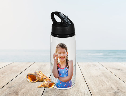 Sports Drink Bottle customised with a photo of a kid. Placed on a table near the ocean. 